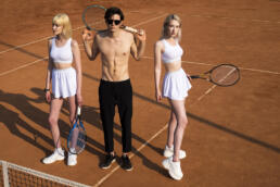 man with two girls in tennis ground
