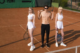 man with two girls on tennis ground