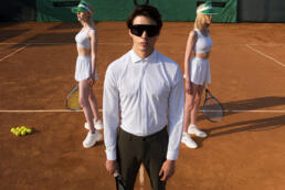 man adb with sunglasses with girls on tennis ground